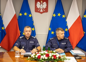 dwaj policjanci siedzą przy stole w trakcie spotkania