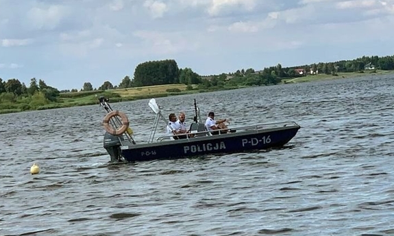 pływająca po akwenie policyjna łódź z trzema policjantami
