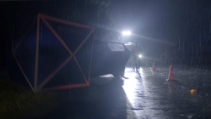 kadr z filmu: pora nocna, miejsce wypadku drogowego, w głębi widoczna postać z latarką w dłoni