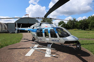 śmigłowiec na lądowisku, w tle hangar