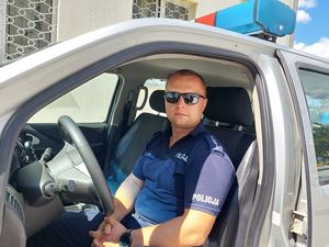 umundurowany policjant siedzi w radiowozie