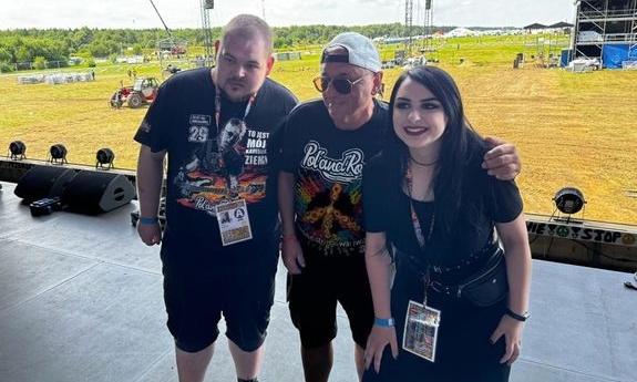 Jagoda i Kamil, którzy w ramach tegorocznego finału WOŚP wylicytowali dzień z policjantami prewencji podczas zabezpieczenia Pol&#039;and&#039;Rock Festival stoją na scenie z mężczyzną