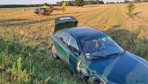 uszkodzony samochód marki Audi, stojący na polu śmigłowiec LPR