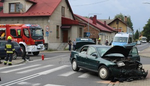 uszkodzony samochód na jezdni w tle wóz strażacki i radiowóz