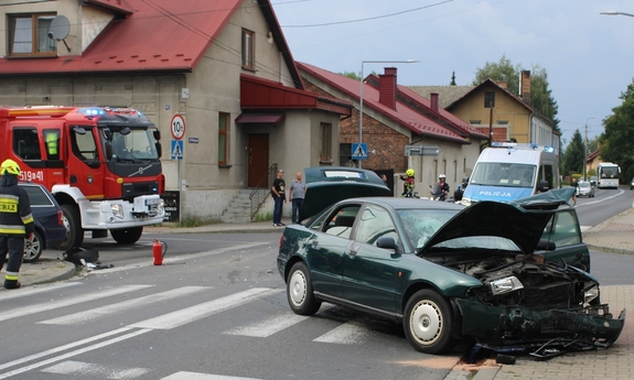 uszkodzony samochód na jezdni w tle wóz strażacki i radiowóz