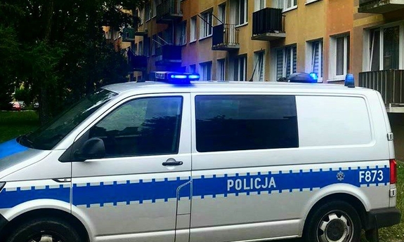 radiowóz policyjny stoi przed blokiem mieszkalnym
