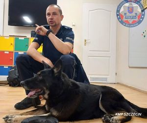 policjant kuca obok psa