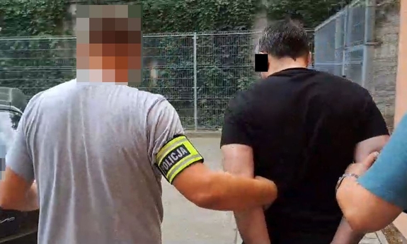 policjanci prowadzą zatrzymanego mężczyznę