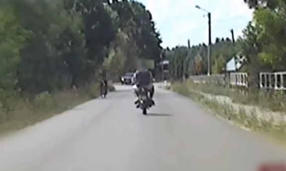 Stopklatka z nagrania wideorejestratora przedstawia motocyklistę i pasażera na motocyklu
