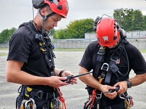 policjanci i strażacy w trakcie ćwiczeń z wykorzystaniem policyjnego Black Hawka