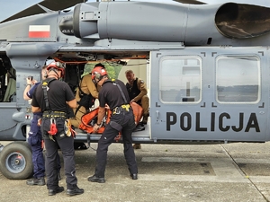 policjanci i strażacy w trakcie ćwiczeń z wykorzystaniem policyjnego Black Hawka