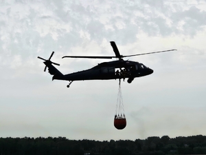 śmigłowiec w locie z podwieszonym zbiornikiem Bambi Bucket