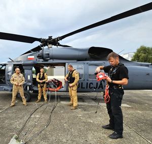 policjanci i strażacy w trakcie ćwiczeń z wykorzystaniem policyjnego Black Hawka