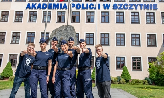 funkcjonariusze stoją przed budynkiem Akademii Policji w Szczytnie