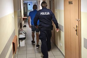 policjant idzie z zatrzymanym