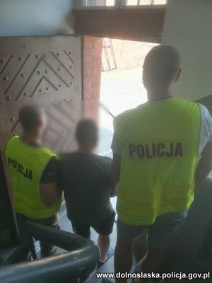 policjanci idą z zatrzymanym