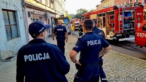 policjanci i strażacy przy ewakuowanym budynku