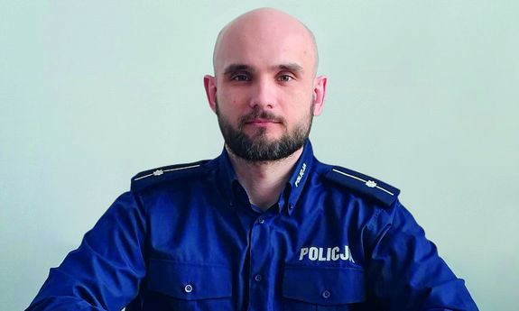 policjant siedzi przy biurku