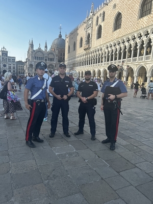 Dwóch polskich i dwóch włoskich policjantów na placu w tle zabytkowy budynek.