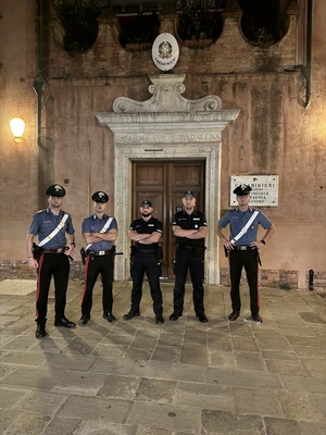 Polscy i włoscy policjanci na tle wejścia do budynku karabinieri.