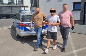 policjanci prowadzą zatrzymanego