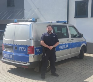 Policjant stoi przy radiowozie