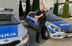 policjant na tle radiowozów