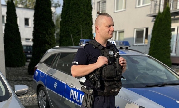 policjant na tle radiowozów