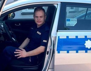 na zdjęciu umundurowany policjant siedzi w radiowozie