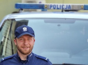 policjant, w tle radiowóz