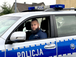 policjant siedzi za kierownicą radiowozu