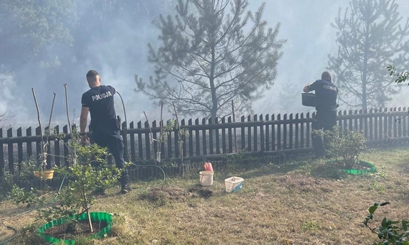 dwaj policjanci gaszą pożar