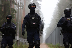 Trzej policjanci patrolują pas graniczny.