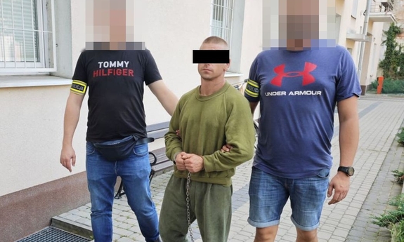 dwóch policjantów prowadzi zatrzymanego mężczyznę