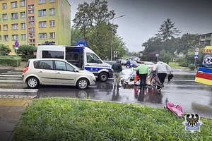 wypadek drogowy - samochód osobowy na pasach obok radiowóz policyjny i karetka, na ulicy leżą osoby przykrywane przez inne kocami ratunkowymi