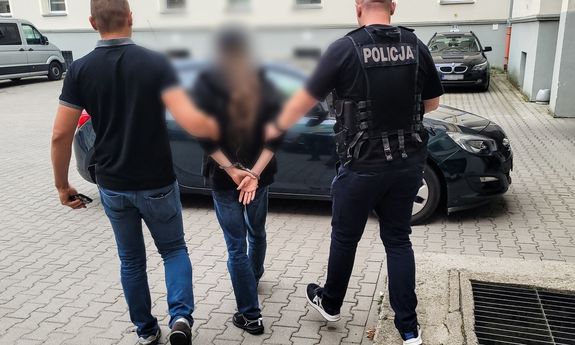 policjanci idą z zatrzymanym