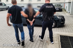 policjanci idą z zatrzymanym