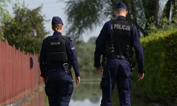 policjanci stoją przy zalanej ulicy