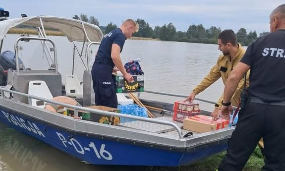 policjanci ładują rzeczy na łódź