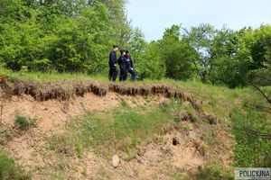 trójka policjantów stoi na skarpie