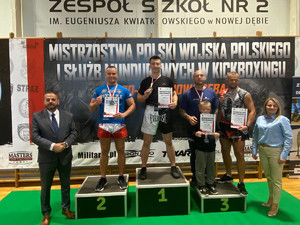 grupa zawodników na podium