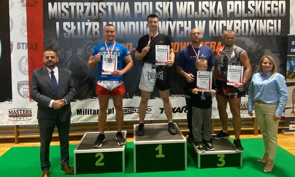 grupa zawodników na podium