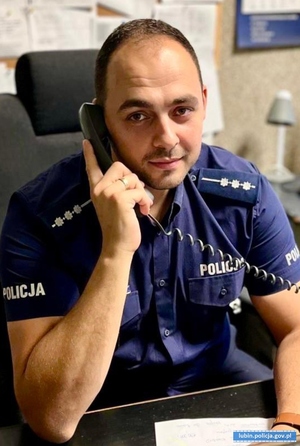 policjant siedzi przy biurku