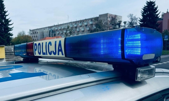 Dach radiowozu policyjnego. Na sygnalizatorze świetlnym na dachu radiowozu policyjnego napis Policja.