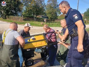 policjanci schodzą z łódki z agregatem.