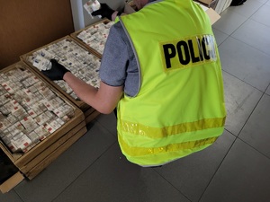 Zabezpieczone przez policjantów wyroby tytoniowe bez wymaganych znaków . Policjant podczas czynności.