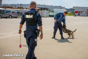 Policjant z psem i pozorant w trakcie zawodów kynologicznych.