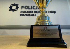 Na zdjęciu puchar. W tle napis na ścianie Komenda Rejonowa Policji Warszawa I.