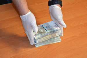 Policjant układa banknoty w stosie.