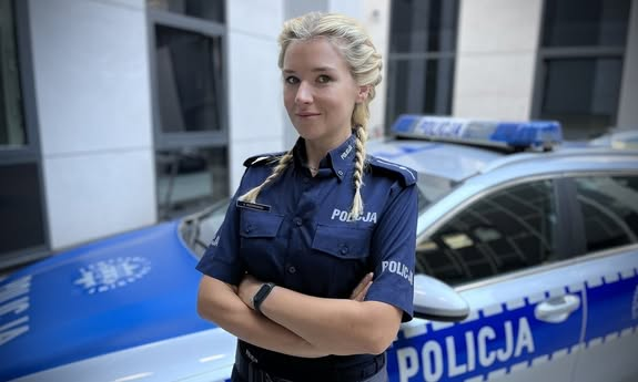 policjantka stoi przed radiowozem.